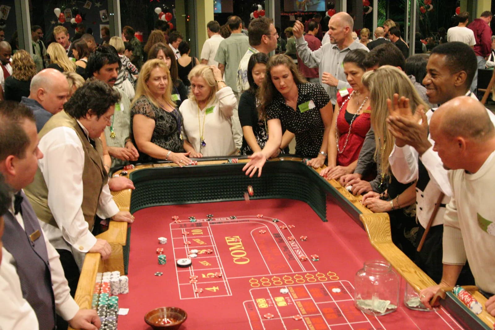 Guests crowd a craps table run by professional dealers at a corporate casino night in Los Angeles